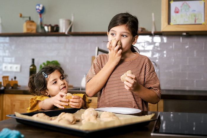 Foto: Sarah Wiener Stiftung I photothek Zwei Kinder stehen in der Küche und riechen an selbstgebackenen Brötchen