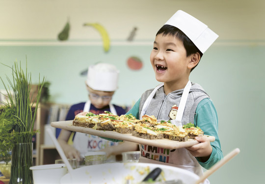 Foto: Sarah Wiener Stiftung | photothek Ein Kind hält ein Tablett mit Essen darauf