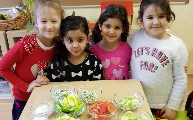 Kinder präsentieren ihre selbst gekochte Mahlzeit in einer Berliner Kita.