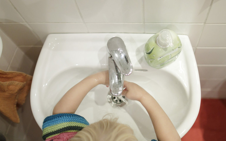 Ein Kind wäscht sich an einem Waschbecken die Hände im Rahmen einer Ich kann kochen!-Kochaktion in der Kita.