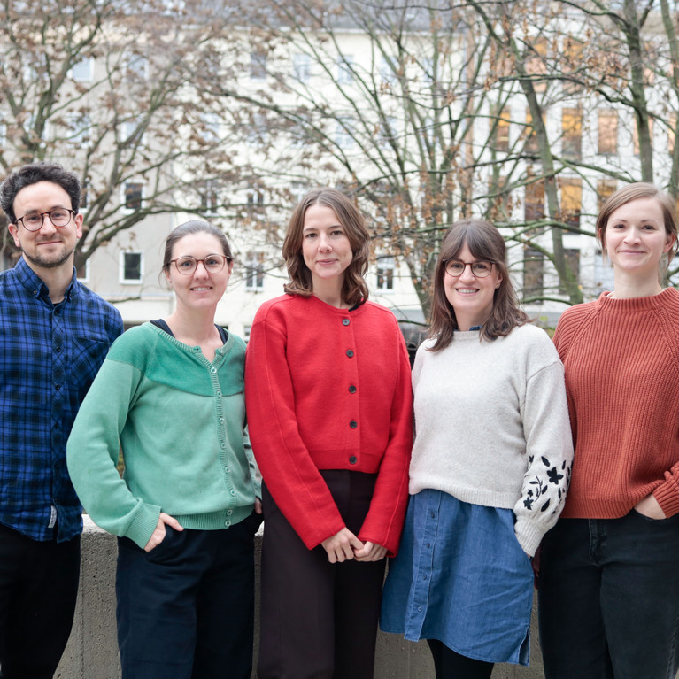 Vier Frauen und ein Mann lächeln in die Kamera